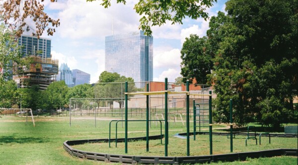 A playground in a park with the Austin Texas skyline in the background