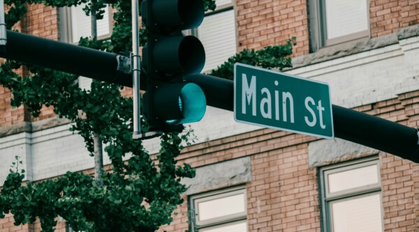 A street sign reading "Main St" next to a traffic light