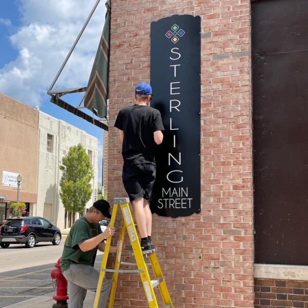 Instalación de un rótulo con la marca Main Street en un edificio de ladrillo en Sterling, Illinois