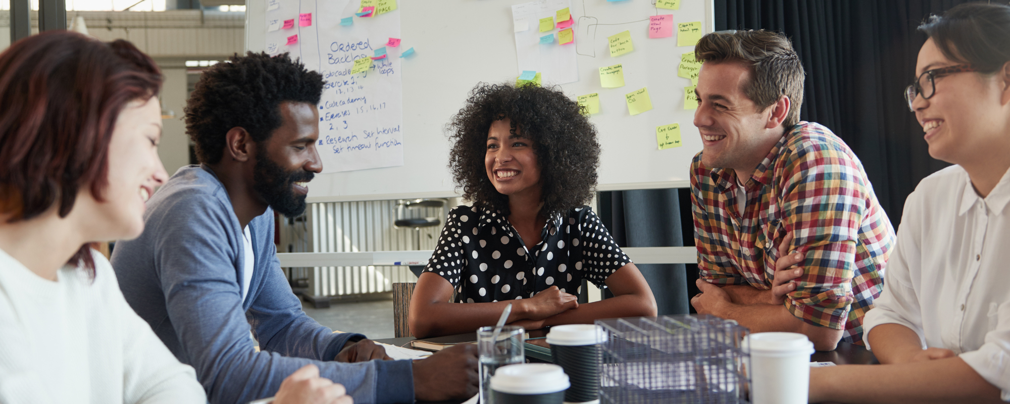 A diverse group of young business professionals having a meeting around a conference table.