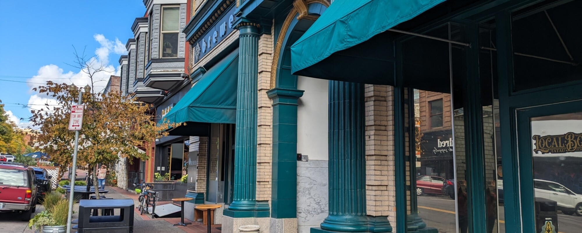 A downtown sidewalk with historic buildings along the righthand side.