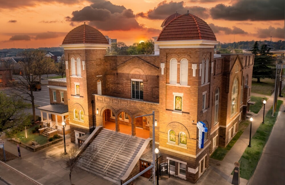 16th Street Baptist Church illuminated by streetlamps at sunset.