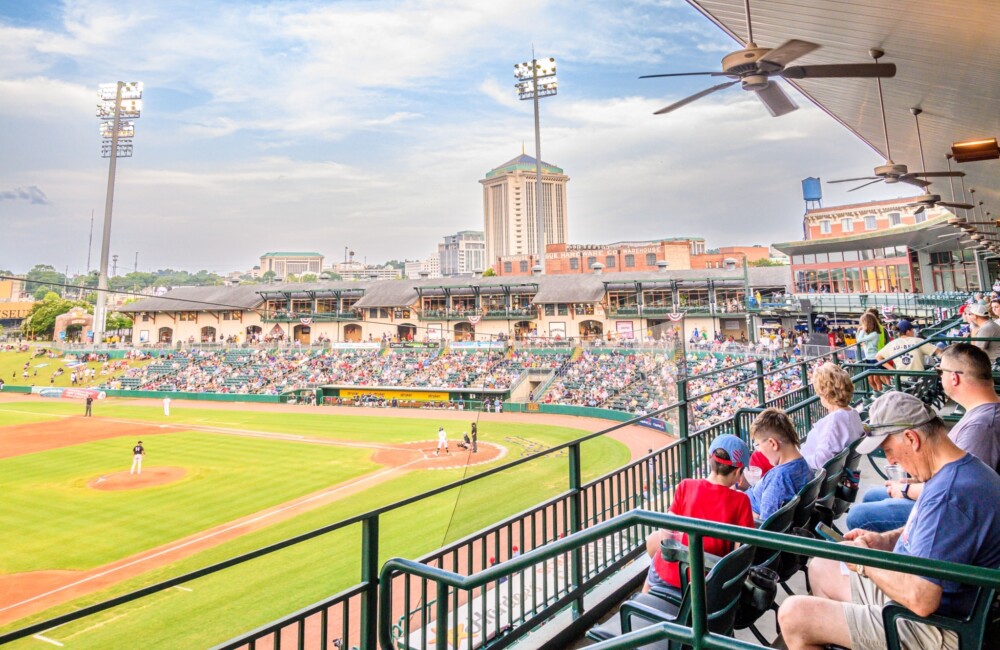 Baseball stadium filled with people while players are on the field.