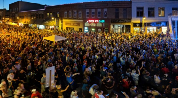 Large crowd gathers outside downtown scene at night
