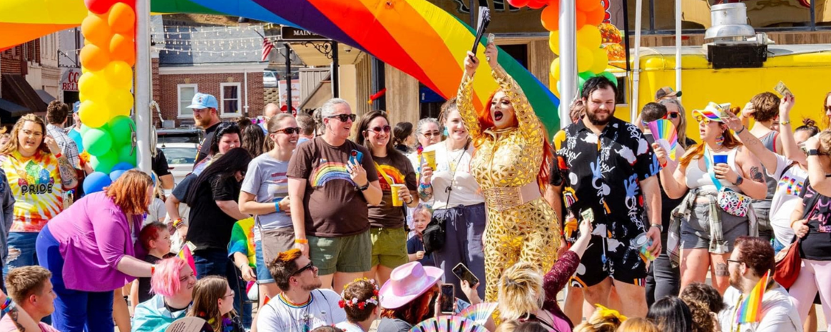 A group of people watching a drag performance at a pride event