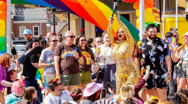 A group of people watching a drag performance at a pride event