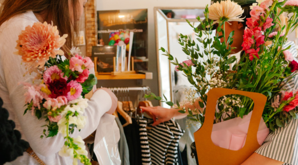 Two flower crawl participants hold their bouquets while they browse the merchandise in a participating retailer.