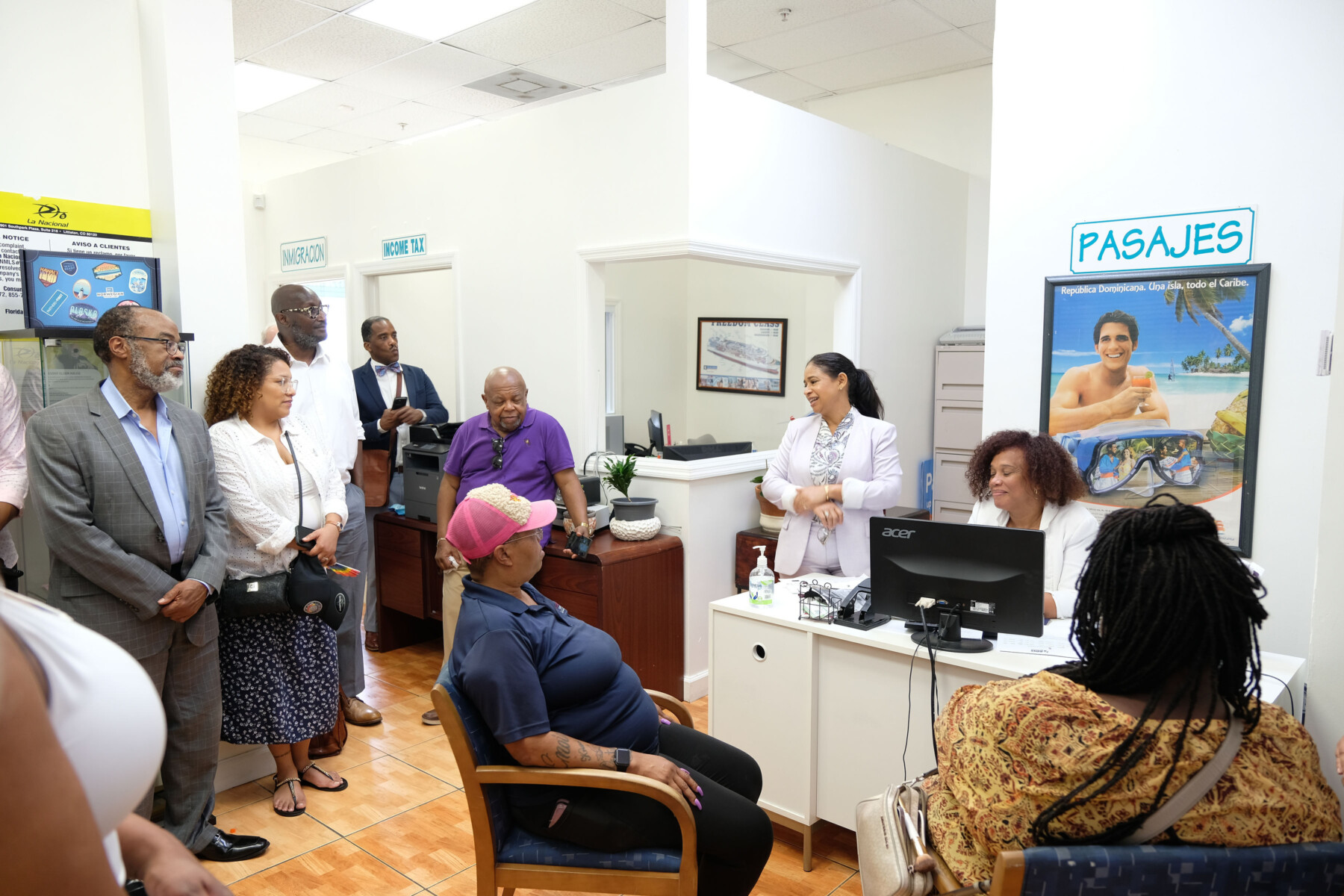 A group of people gather in an office and listen to business owner speak.