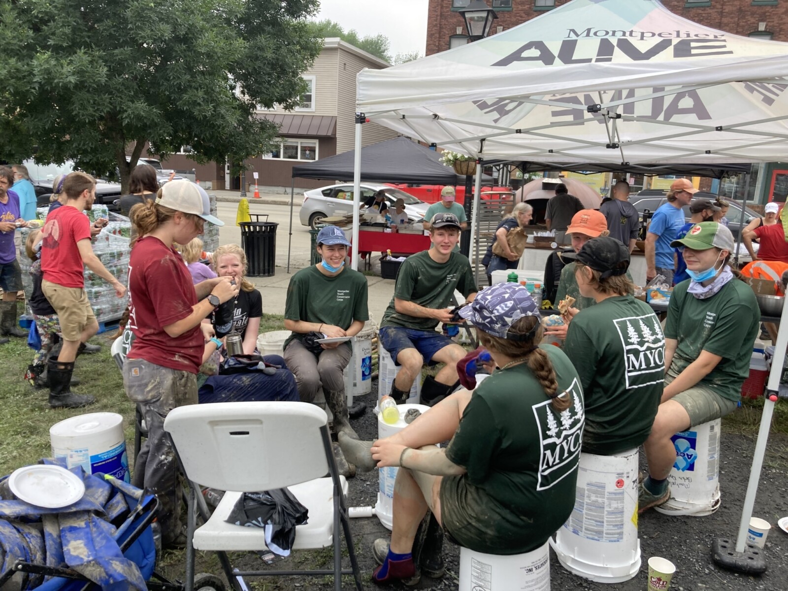 People sitting on chairs and empty buckets taking a break during floor cleanup