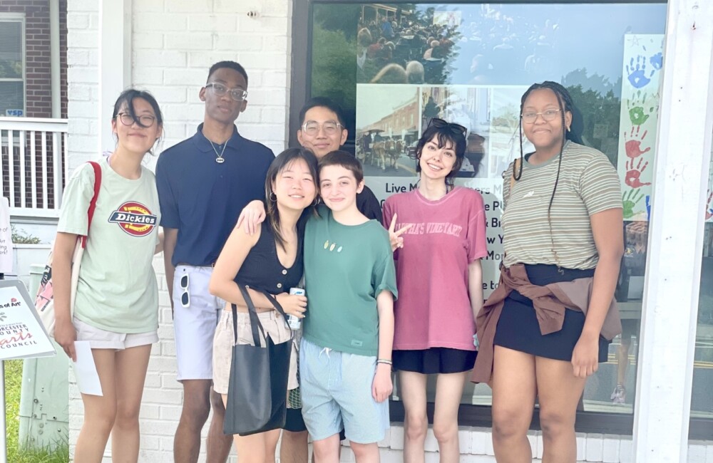 A group of young people standing in front of a welcome center.