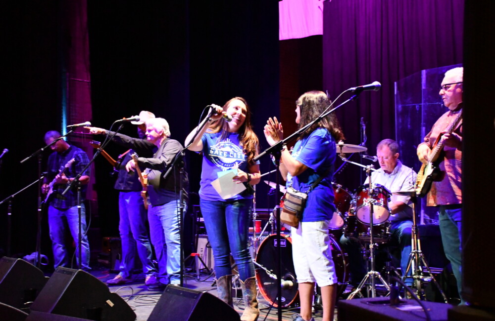 Musicians perform on a stage.