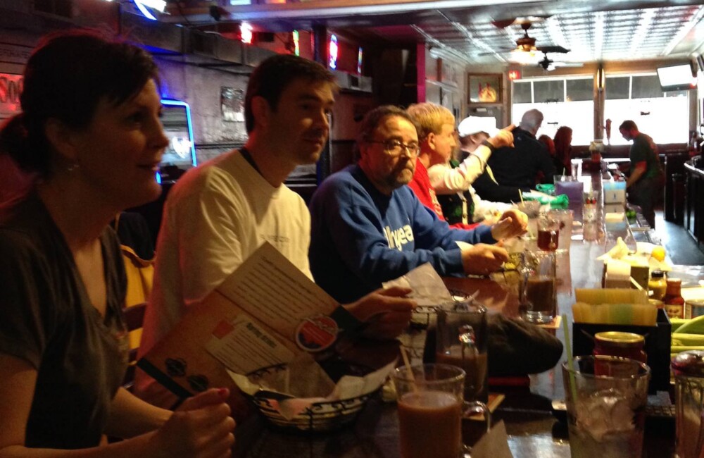 A group of people sitting in a diner looking at menus