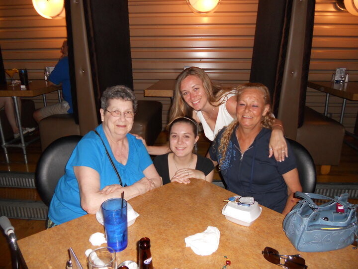 Four women post for a picture at a table in a restaurant