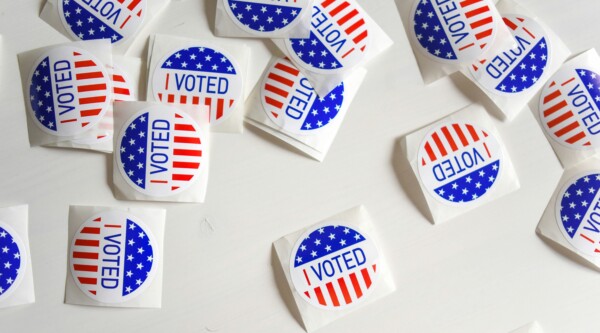 A bunch of stickers on a table saying "I voted"