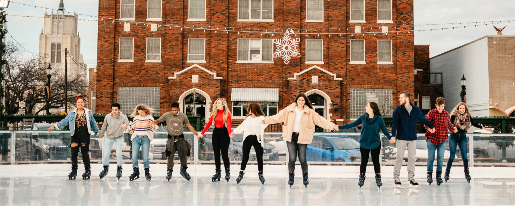 A group of people skating at an outdoor ice rink