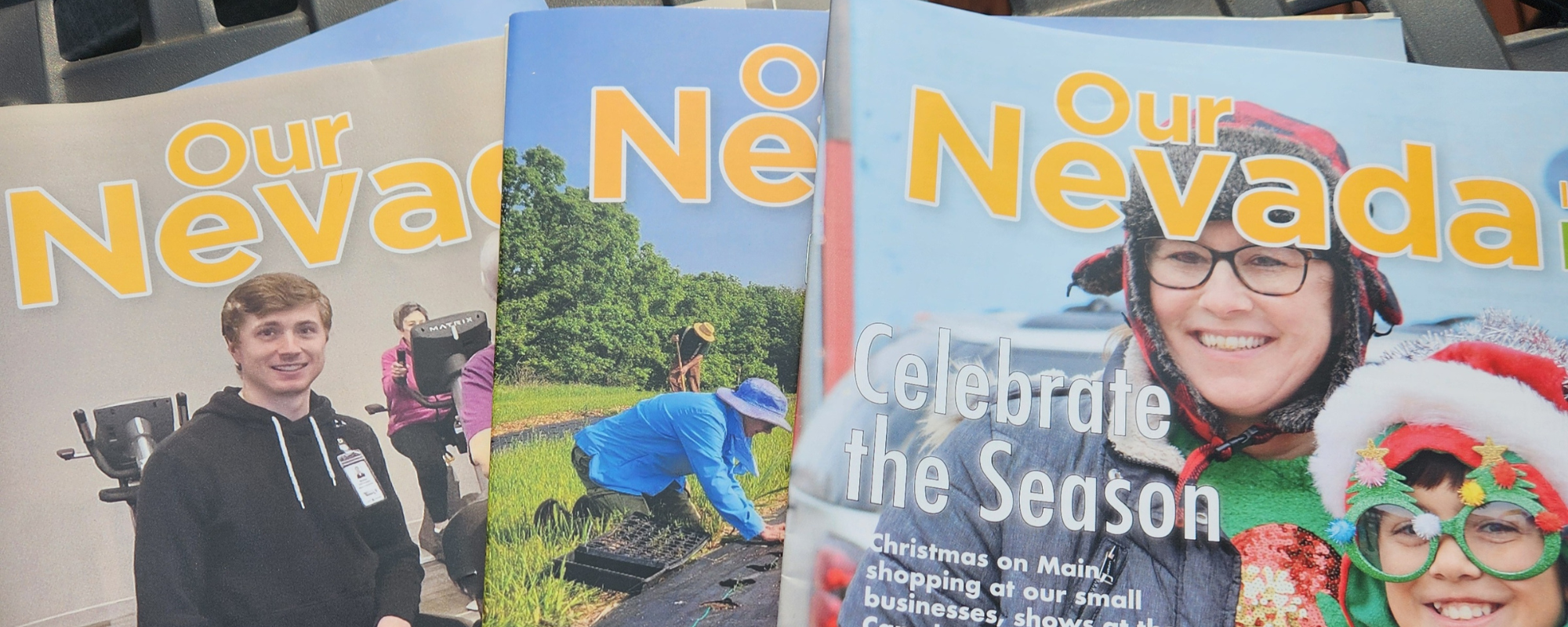 Three editions of 'Our Nevada' laid out on a table