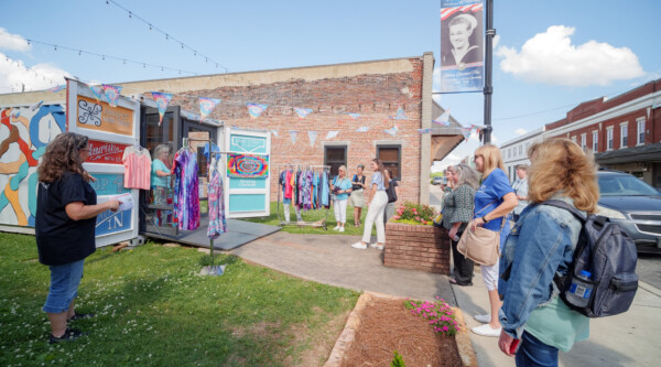 A group of people check out a retail store operating from a storage container.