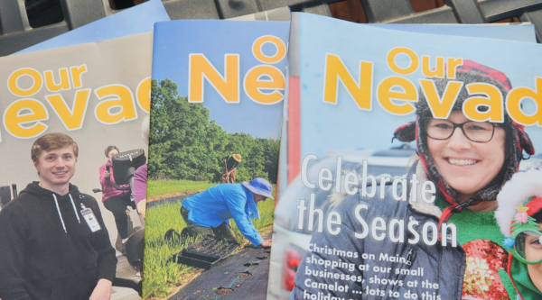 Three editions of 'Our Nevada' laid out on a table