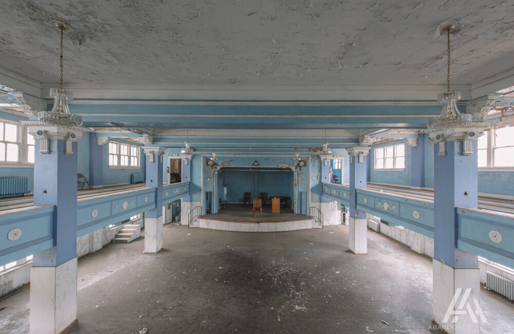 Mezzanine view of a large, open interior space with historic architectural features extant, but deteriorated.