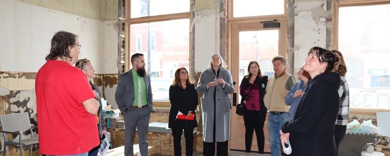 A group of people looking up at the ceiling while touring a historic space