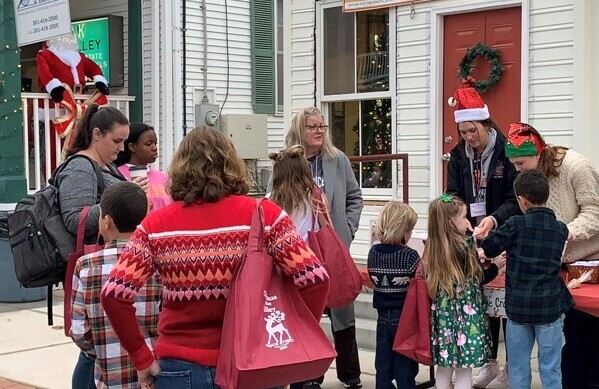 People attending a holiday event give donations to a fundraising booth for the building rehabilitation