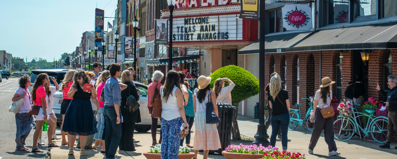 People standing on a street looking at historic buildings