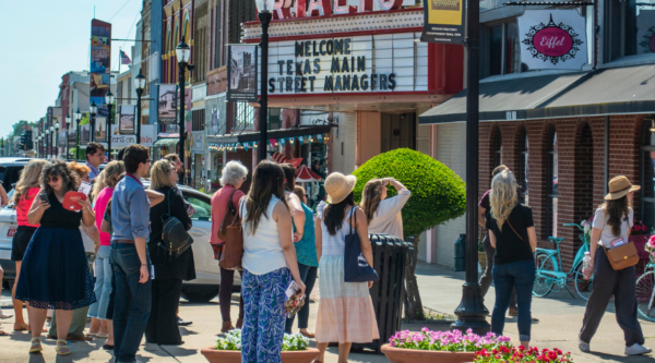 People standing on a street looking at historic buildings