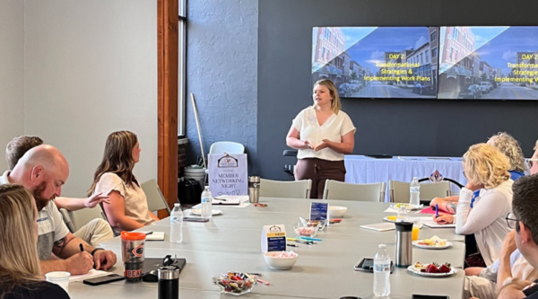 A group of people in a conference room listening to a presentation