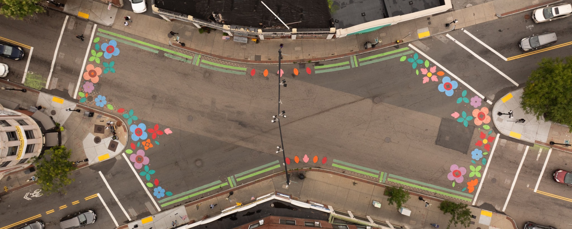 Aerial photo of an intersection with flower murals on all the crosswalks