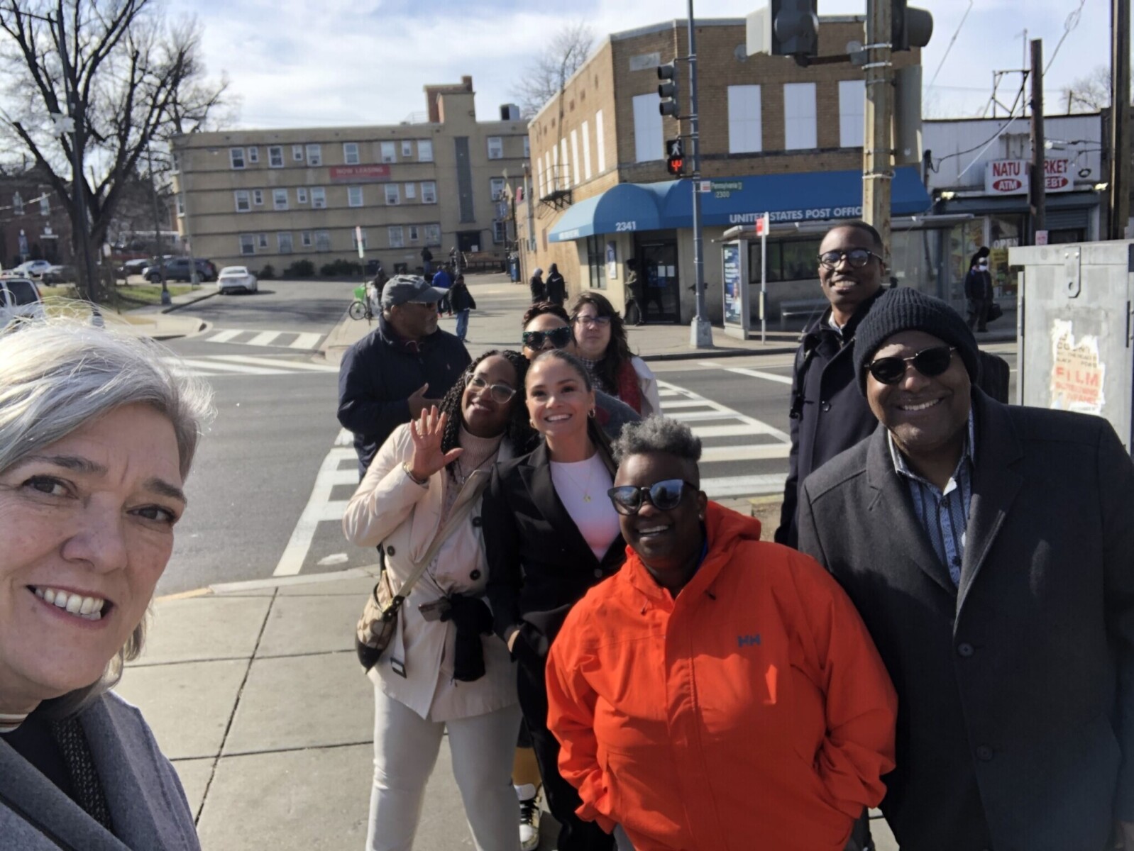 A group of people posing for a selfie on a downtown street