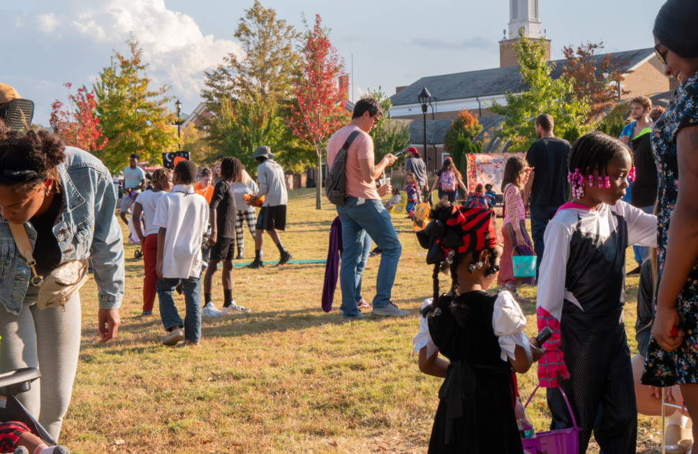 People in halloween costumes playing games on a grassy lawn