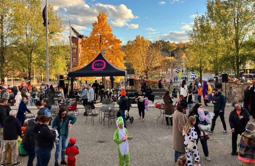 People wearing Halloween costumes gathered in a downtown park