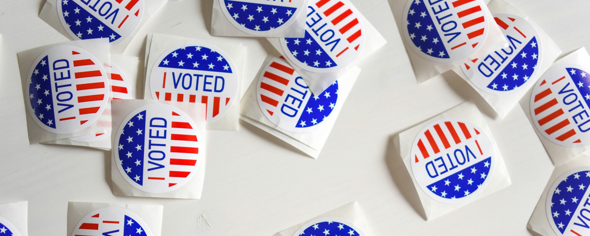 A bunch of stickers on a table saying "I voted"