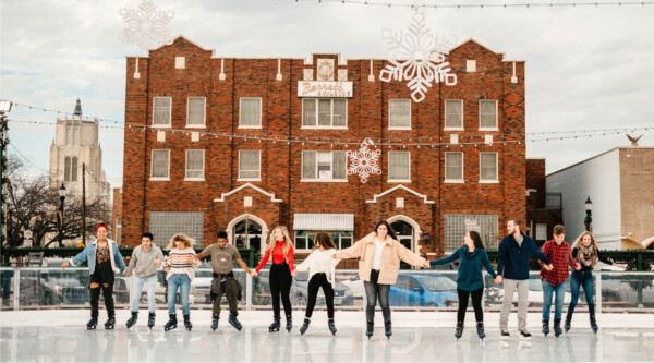 A group of people skating at an outdoor ice rink