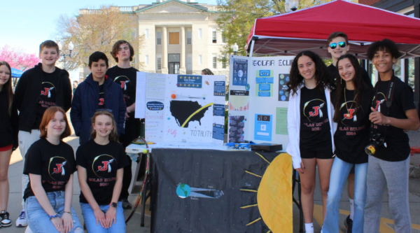 A group of kids posing with a poster board showing their science research