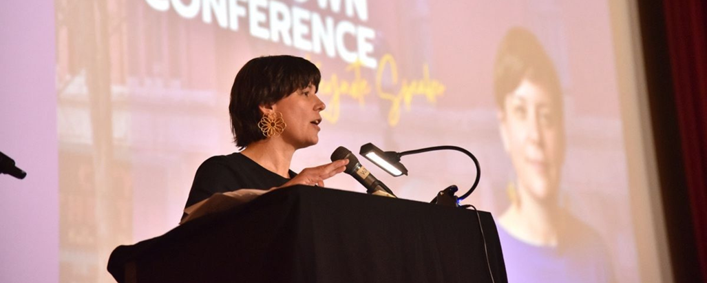 Erin Barnes speaking at a podium during the Maine Downtown Conference