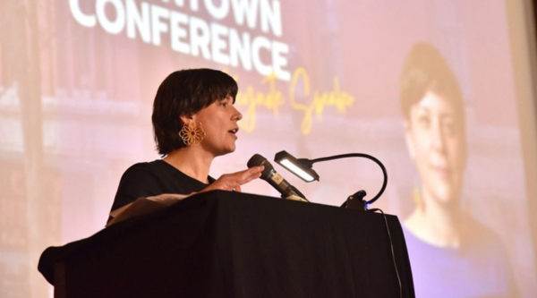 Erin Barnes speaking at a podium during the Maine Downtown Conference