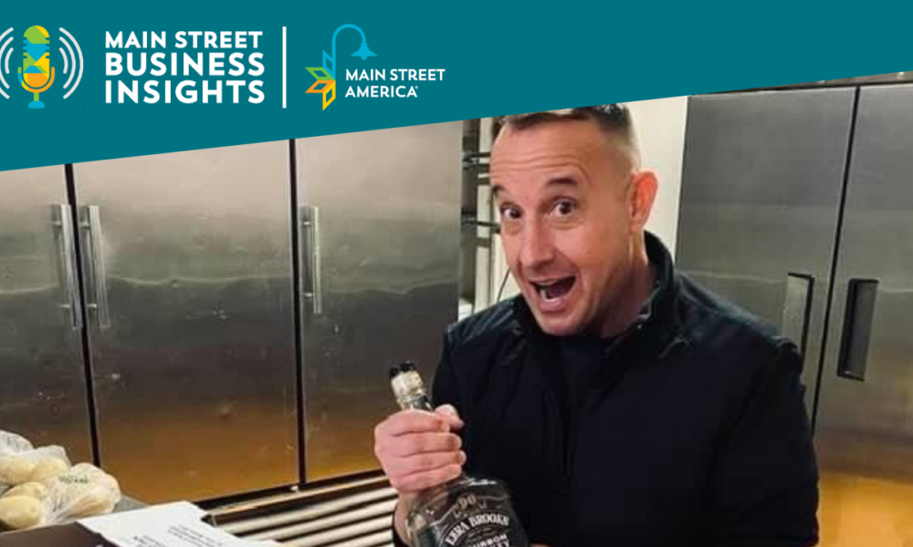 Man in industrial kitchen holds bottle of whiskey