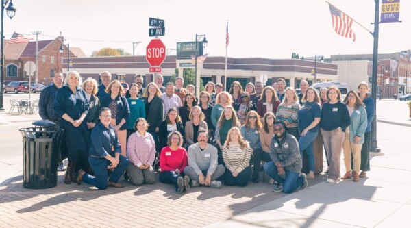 Un gran grupo de personas posa en la acera en Nevada, Iowa