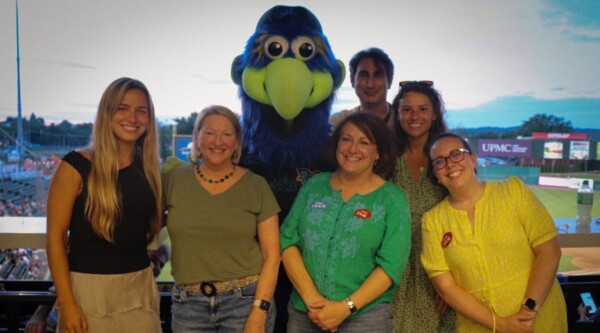 A group of people pose with a sports mascot