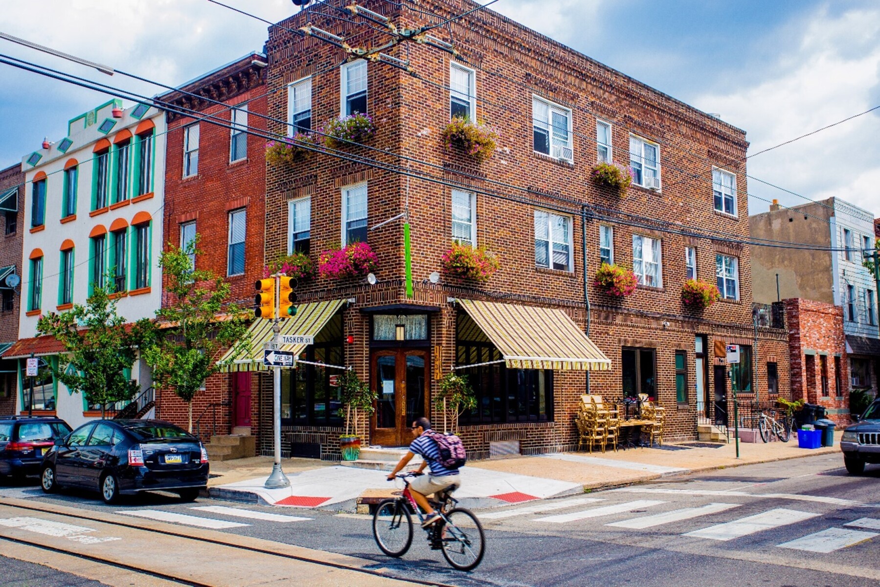 A man rides a bicycle past historic brick buildings in Philadelphia