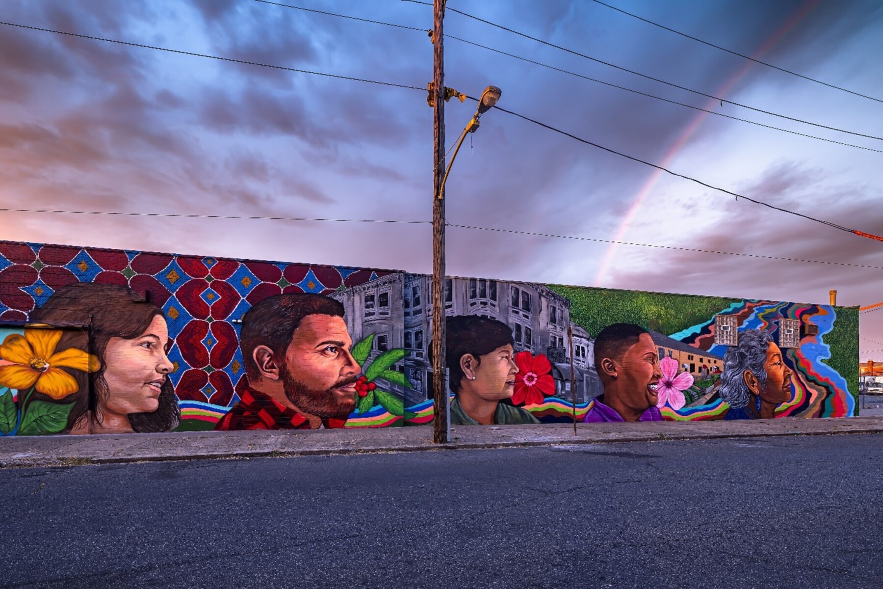 A mural featuring the faces of people with a background of cultural symbols