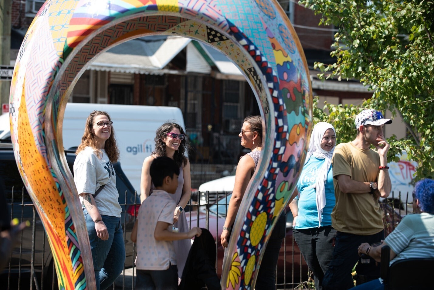 People enjoying an event near an art sculpture