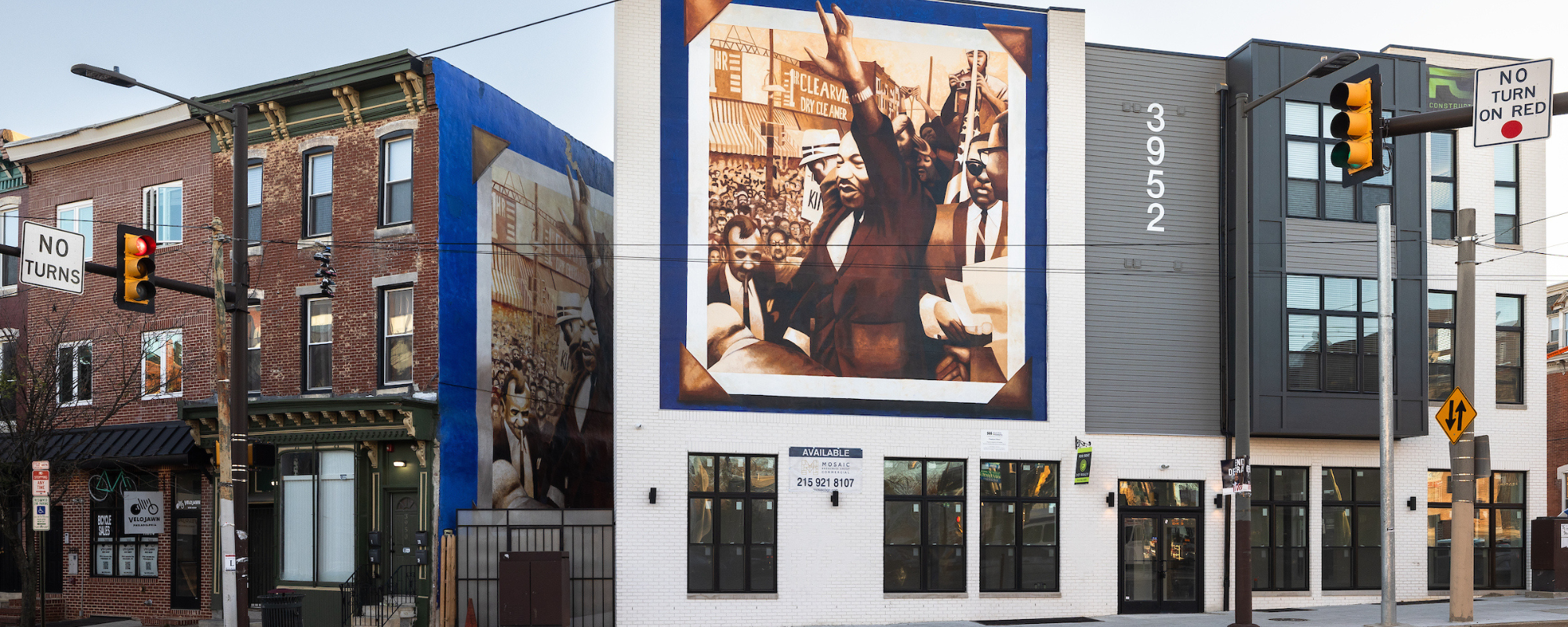 Historic brick buildings. One of them features a mural of MLK Jr.