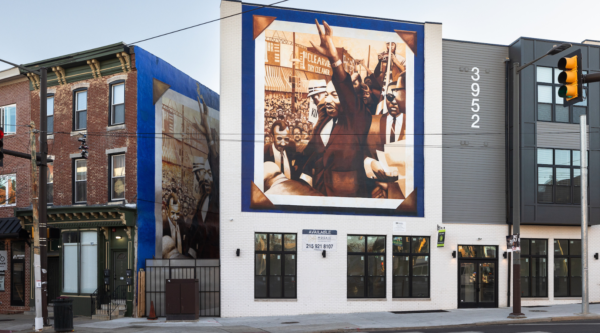 Historic brick buildings. One of them features a mural of MLK Jr.