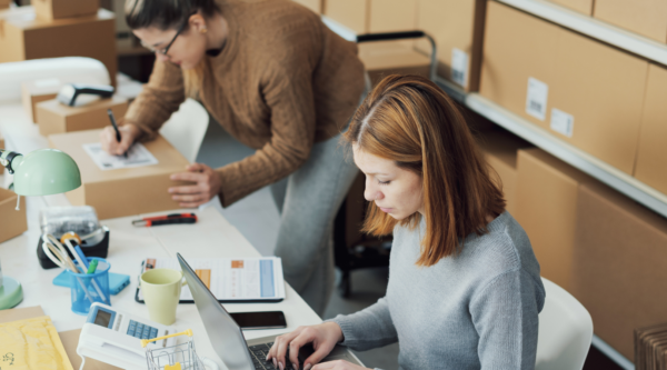 Two women process inventory and packages for a small business