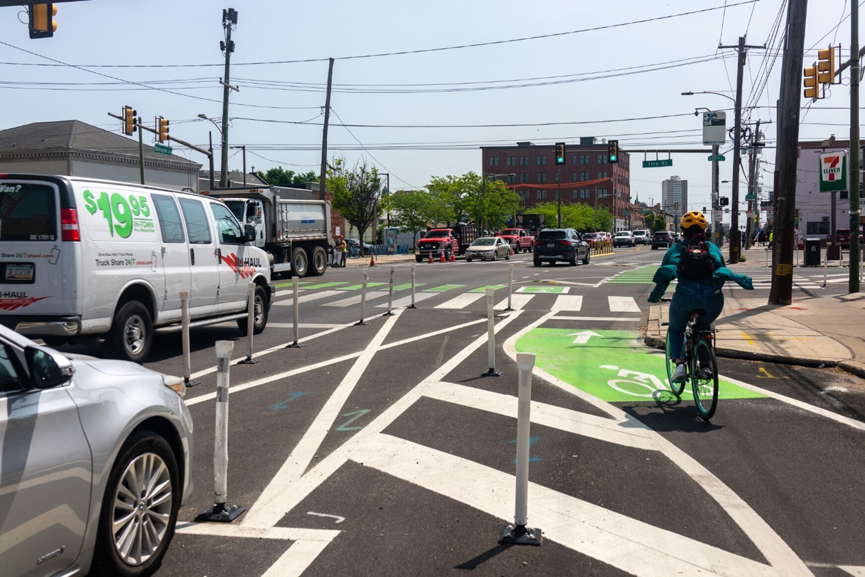 Cars drive past a cyclist in a bike lane