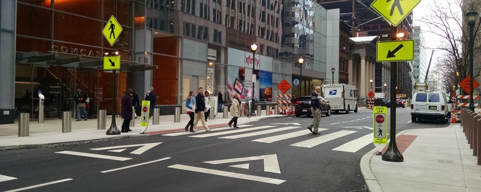 People traversing a crosswalk in downtown Philadelphia