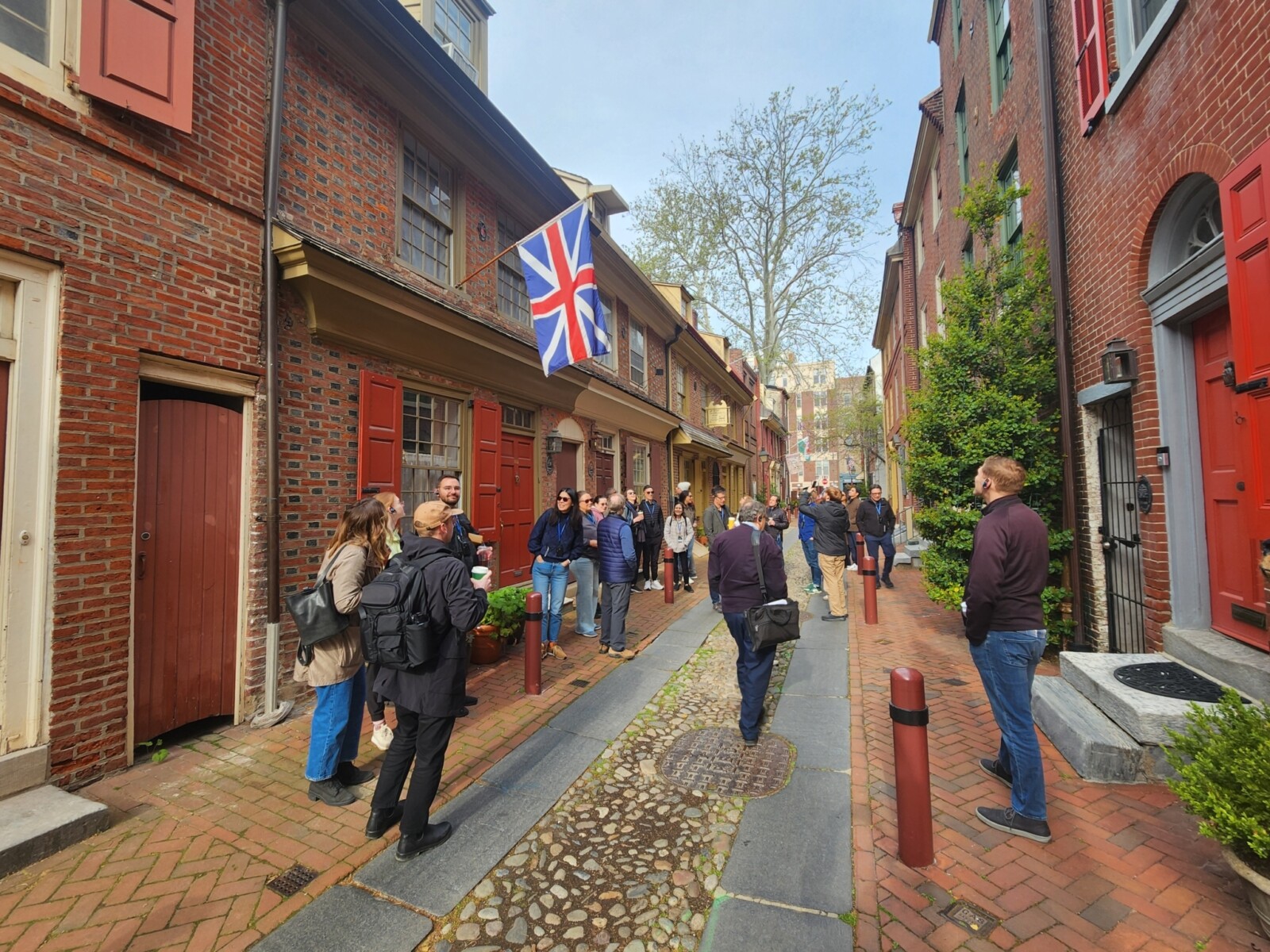 Callejón histórico con edificios de ladrillo rojo y banderas británicas