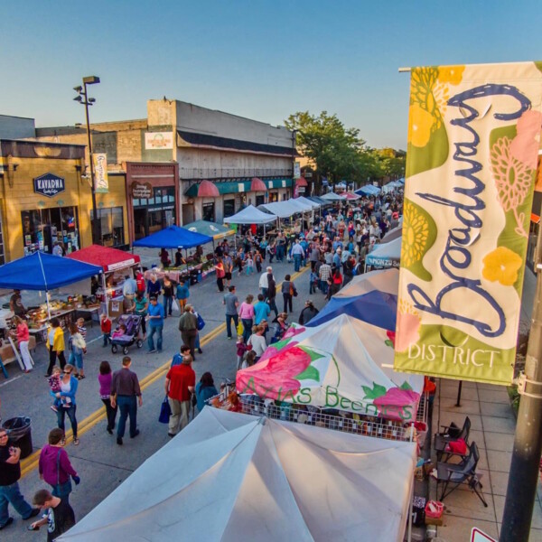 Aerial view of busy downtown street with pedestrians and vendors.